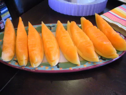 2K Quad HD PC desktop wallpaper of honeydew melon slices arranged on a colorful platter; food, melon.