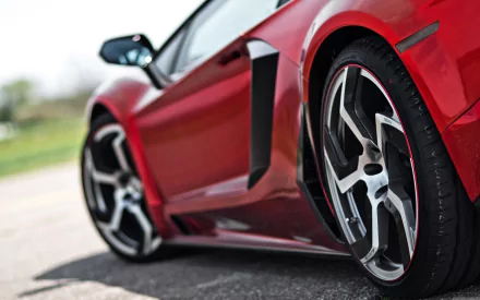 Close-up HD wallpaper of a red Lamborghini Aventador focusing on its wheel, showcasing the car’s sleek design and engineering.