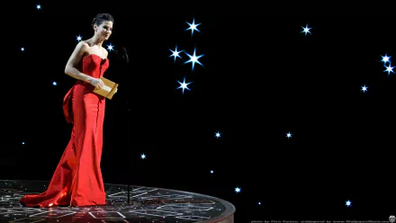 HD PC desktop wallpaper featuring celebrity Sandra Bullock in a red gown standing on a starry stage with a dark background.