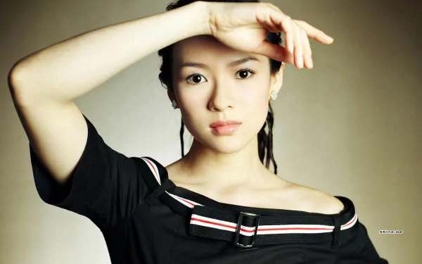 HD desktop wallpaper featuring celebrity Zhang Ziyi posing with her arm raised, wearing a black off-shoulder top against a neutral background.