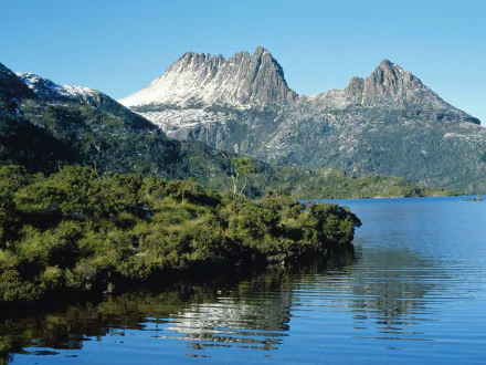 HD desktop wallpaper featuring Cradle Mountain rising above lush greenery and a calm lake, showcasing stunning natural beauty.