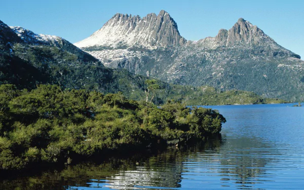 HD desktop wallpaper featuring Cradle Mountain rising above lush greenery and a calm lake, showcasing stunning natural beauty.