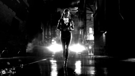 HD PC desktop wallpaper of a dark, moody Sin City movie scene featuring a solitary figure walking down a rain-soaked street with bright headlights behind.