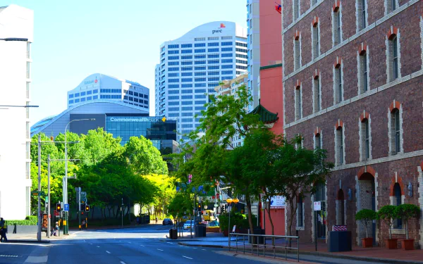Sunlit city street in Sydney's Darling Harbour, featuring modern buildings and a clear blue sky, captured in high definition for a desktop wallpaper.