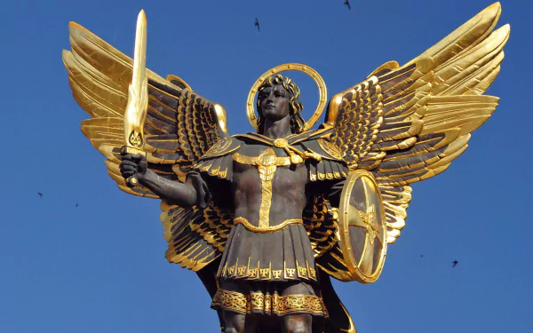 HD PC desktop wallpaper featuring a detailed man-made statue of a winged warrior holding a sword and shield against a clear blue sky.