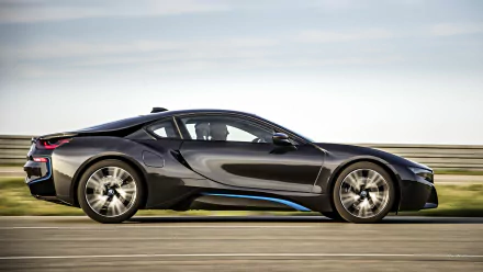 A sleek BMW i8 drives along a scenic road, captured in high definition. This dynamic image serves as an impressive desktop wallpaper and background.