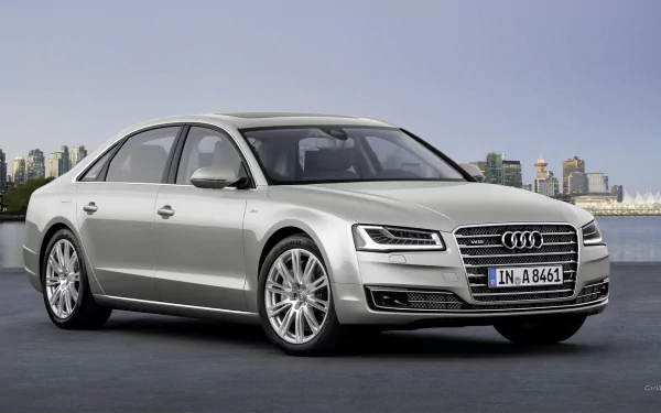 A sleek silver Audi A8 stands prominently against a city skyline, captured in high-definition, serving as an elegant desktop wallpaper and background.