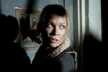 A dramatic scene featuring Laurie Holden as Andrea from The Walking Dead, capturing her intense expression in a dimly lit setting. An engaging HD wallpaper for fans of the show.