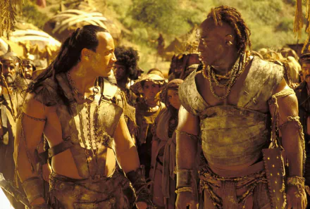 Dwayne Johnson and Michael Clarke Duncan face off in a scene from the movie The Scorpion King, featuring a rich backdrop of adventure and drama. HD wallpaper for fans of the film.