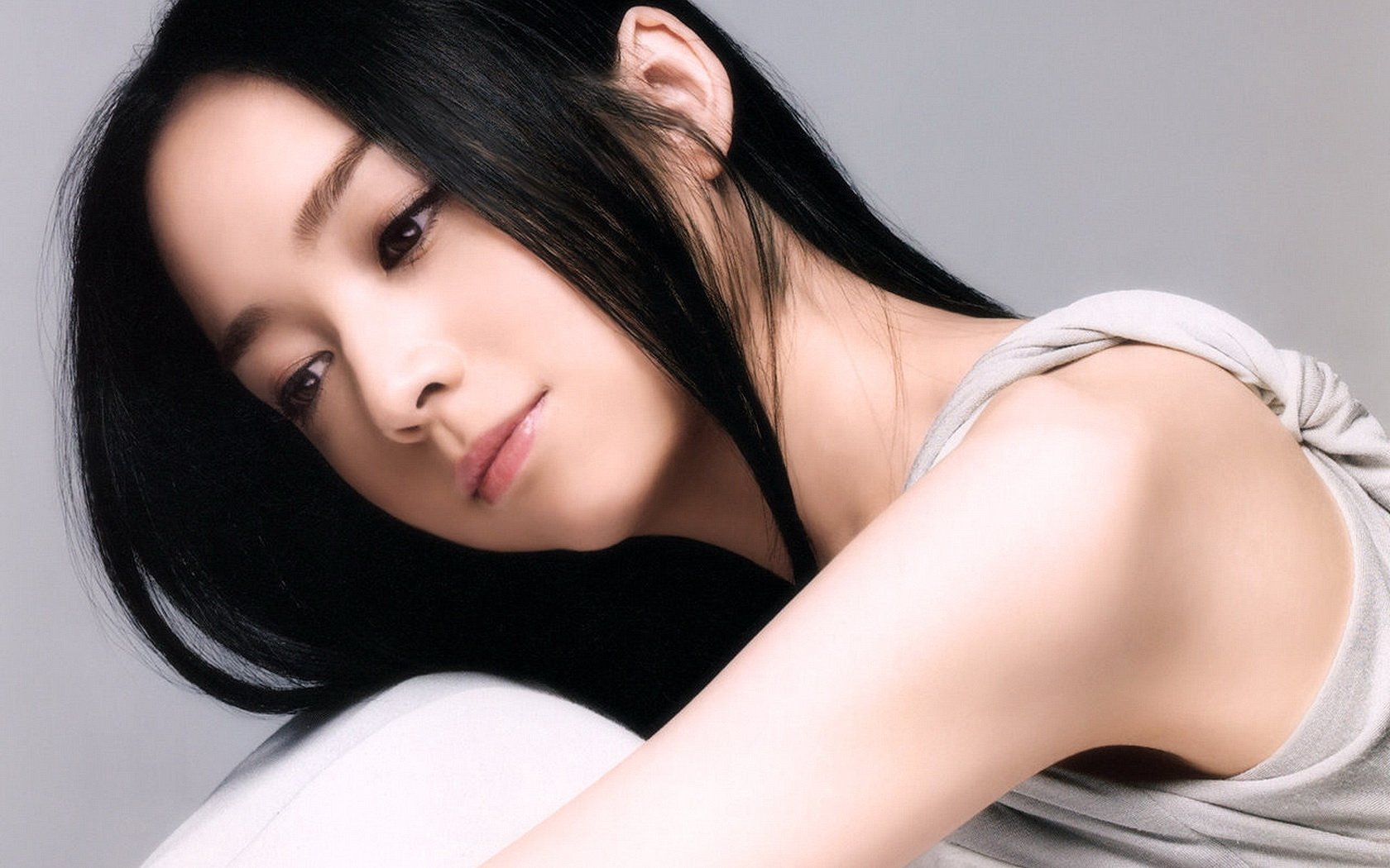HD desktop wallpaper featuring Emiri Miyamoto. The image shows a woman with long, black hair and a serene expression, set against a neutral background.