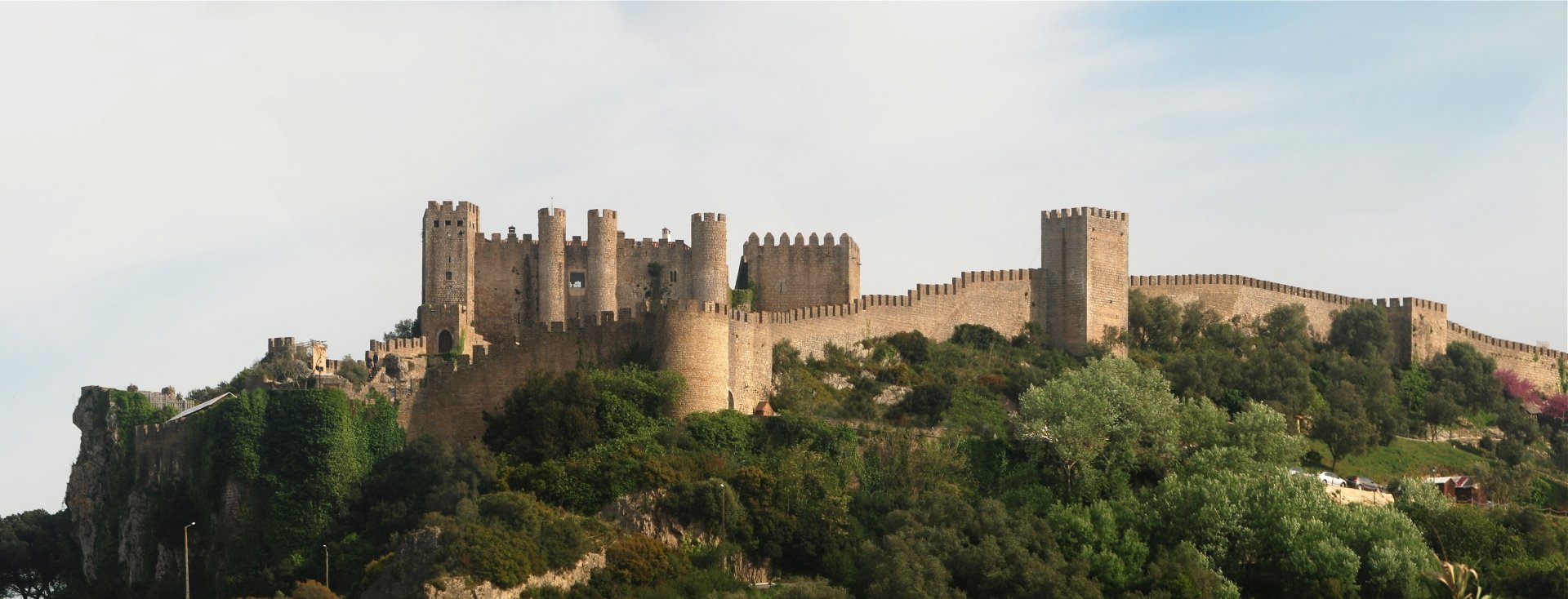 HD PC desktop wallpaper featuring the man-made Obidos Castle set against a clear sky and lush greenery.