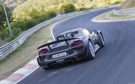 HD PC desktop wallpaper: rear three-quarter view of a Porsche 918 Spyder vehicle hugging a curving racetrack background.