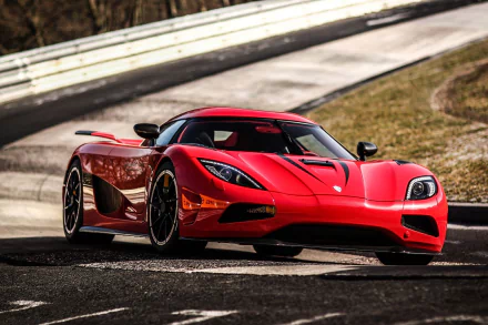 HD desktop wallpaper showcasing the Koenigsegg Agera R, a sleek, red supercar, on a racetrack. The high-definition image highlights the vehicle's design and powerful presence.