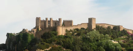 HD PC desktop wallpaper featuring the man-made Obidos Castle set against a clear sky and lush greenery.