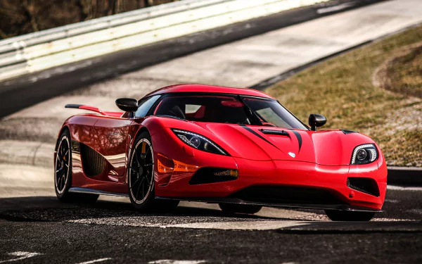 HD desktop wallpaper showcasing the Koenigsegg Agera R, a sleek, red supercar, on a racetrack. The high-definition image highlights the vehicle's design and powerful presence.