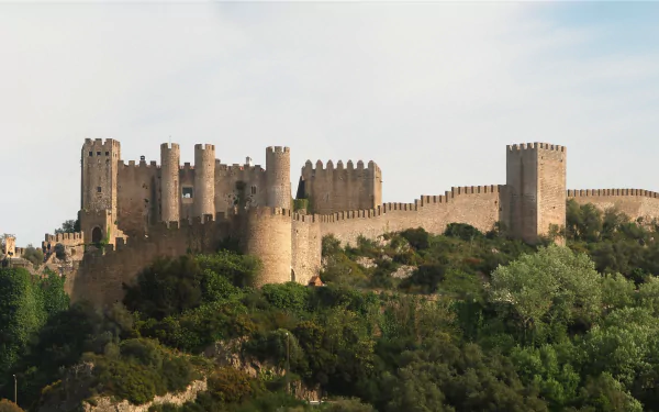 HD PC desktop wallpaper featuring the man-made Obidos Castle set against a clear sky and lush greenery.