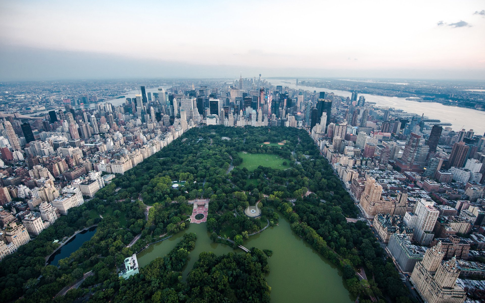 2K Quad HD PC desktop wallpaper: aerial view of Manhattan's Central Park in New York, man-made rectangular green oasis surrounded by skyscrapers and the city skyline.