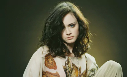 HD desktop wallpaper featuring celebrity Alexis Bledel with dark wavy hair, wearing a patterned blouse against a muted dark background.