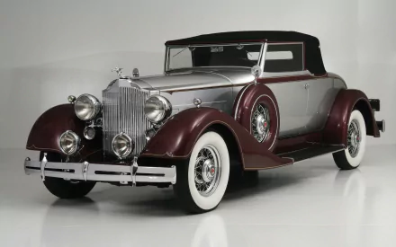 HD PC desktop wallpaper featuring a vintage Packard vehicle in maroon and silver with whitewall tires against a neutral background.