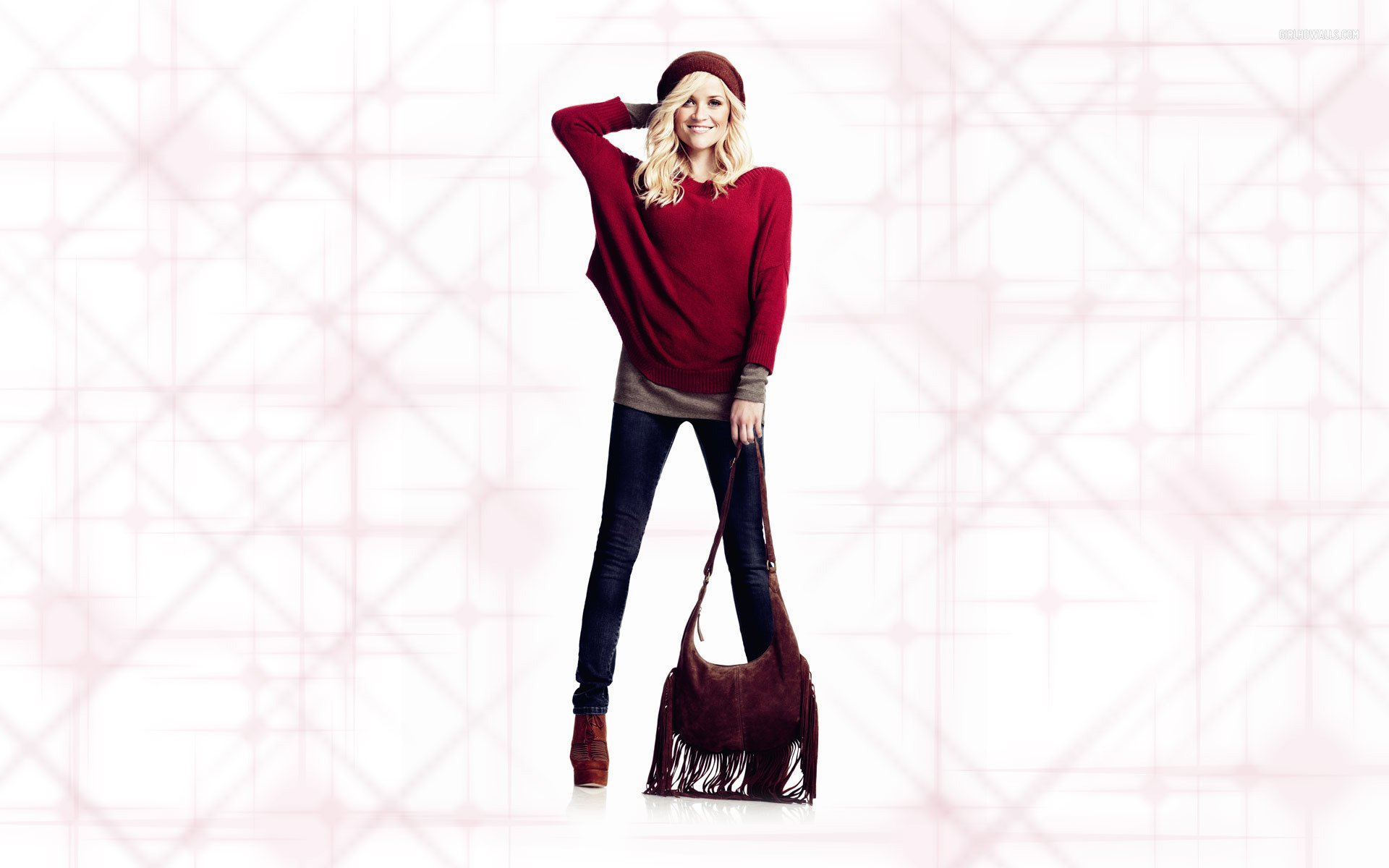 HD PC desktop wallpaper featuring celebrity Reese Witherspoon in a stylish red sweater and black pants, posing confidently with a handbag against a light geometric background.