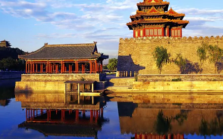 A stunning 4K Ultra HD image of the Forbidden City, showcasing its majestic architecture and vibrant reflections in calm waters under a clear sky.