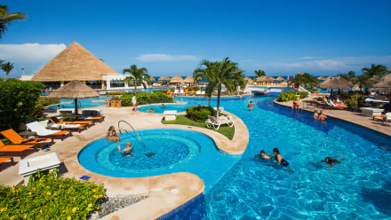 A vibrant 4K Ultra HD image of a man-made resort pool with palm trees, lounge chairs, and visitors enjoying a sunny holiday.