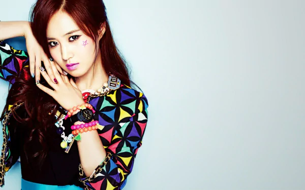 HD desktop wallpaper of a Korean woman with long hair, wearing colorful patterned clothing and bracelets, posing against a light, plain background.