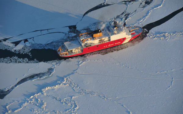 A 4K Ultra HD image of a red icebreaker ship navigating through cracked sea ice, showcasing a powerful vehicle breaking through frozen waters.