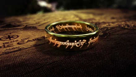 A high-definition wallpaper featuring the One Ring from *The Lord of the Rings*, resting on an ancient map, beautifully illuminated and engraved with Elvish script.