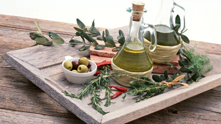HD PC desktop wallpaper featuring fresh olives, olive oil bottles, and herbs arranged on a rustic wooden tray, showcasing vibrant food ingredients and natural textures.
