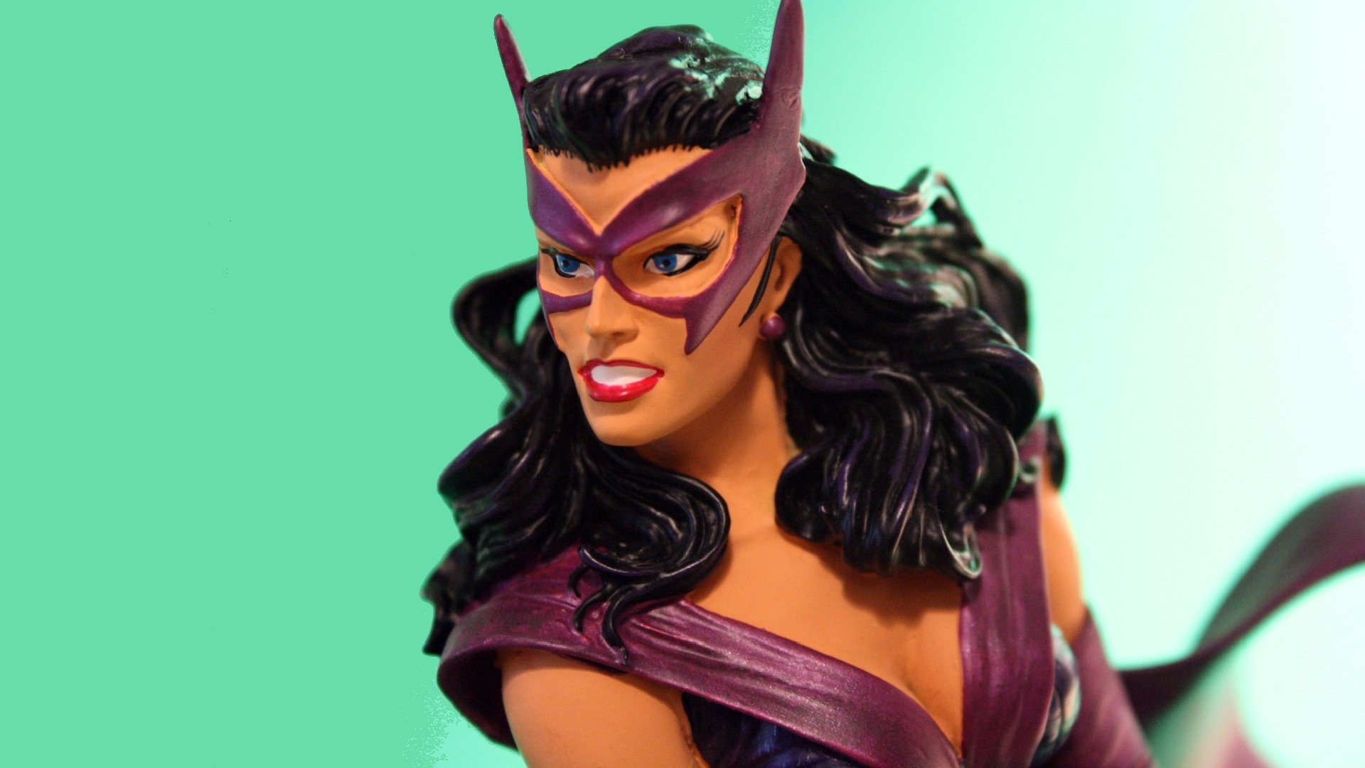 Close-up of a Huntress (DC Comics) figure in hunting costume, featured as a vibrant HD PC desktop wallpaper and background.