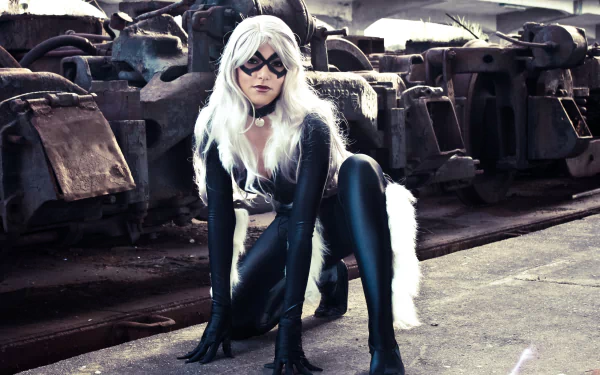 A woman in a striking Black Cat (Marvel Comics) cosplay poses confidently in a gritty industrial setting, showcasing her feline-inspired attire against a dramatic background.