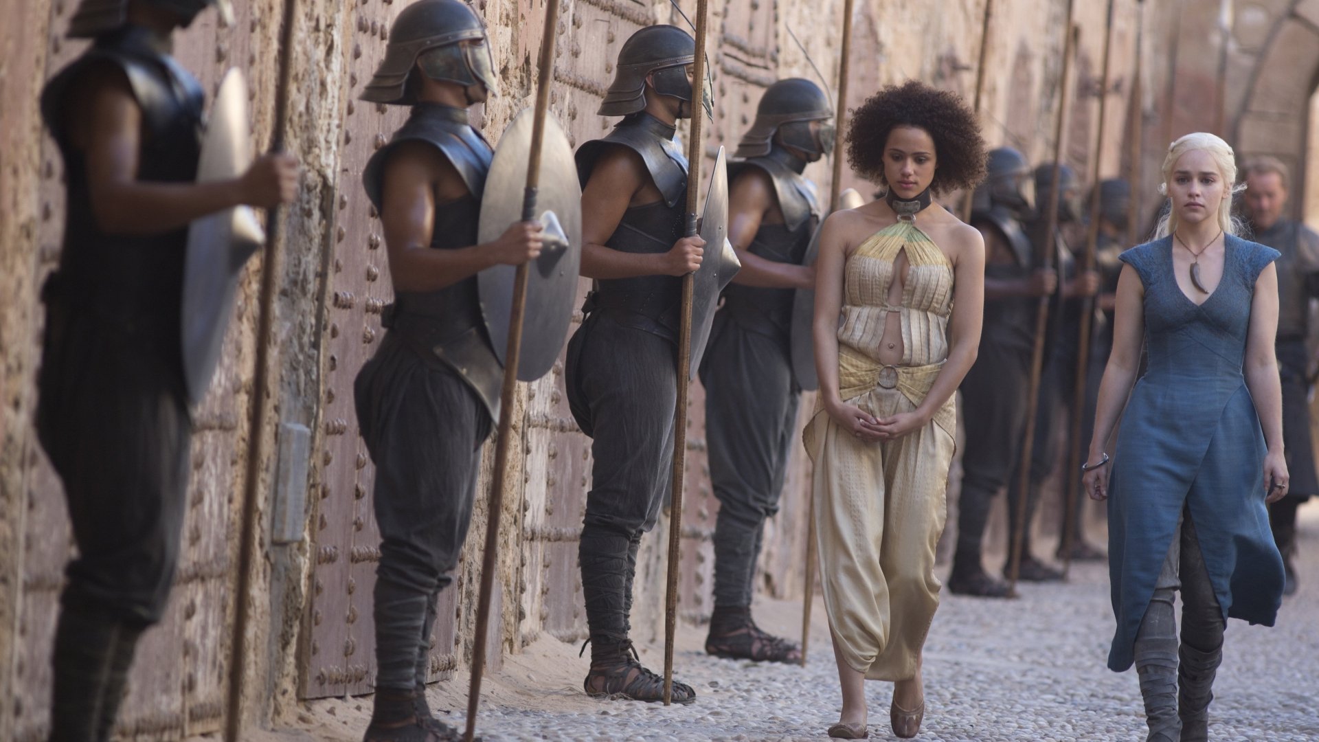 Missandei and Daenerys Targaryen from Game of Thrones walk past Unsullied soldiers in a 4K Ultra HD PC desktop wallpaper featuring Nathalie Emmanuel and Emilia Clarke.