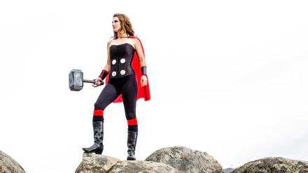 4K Ultra HD PC desktop wallpaper featuring a woman in detailed Thor cosplay standing confidently on rocks with a hammer and red cape against a white background.