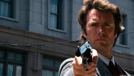 Clint Eastwood as Harry Callahan in Magnum Force, featuring an intense moment with the character aiming a gun on a city street, designed as an HD desktop wallpaper.