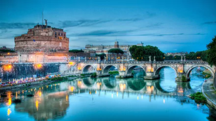 Night 2K Quad HD desktop wallpaper of the man-made Castel Sant'Angelo and Ponte Sant'Angelo spanning the Tiber, illuminated at night with shimmering reflections.