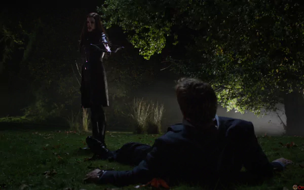 Huntress from Arrow TV show stands over a fallen man in a dark, misty outdoor scene, captured in this HD PC desktop wallpaper background.