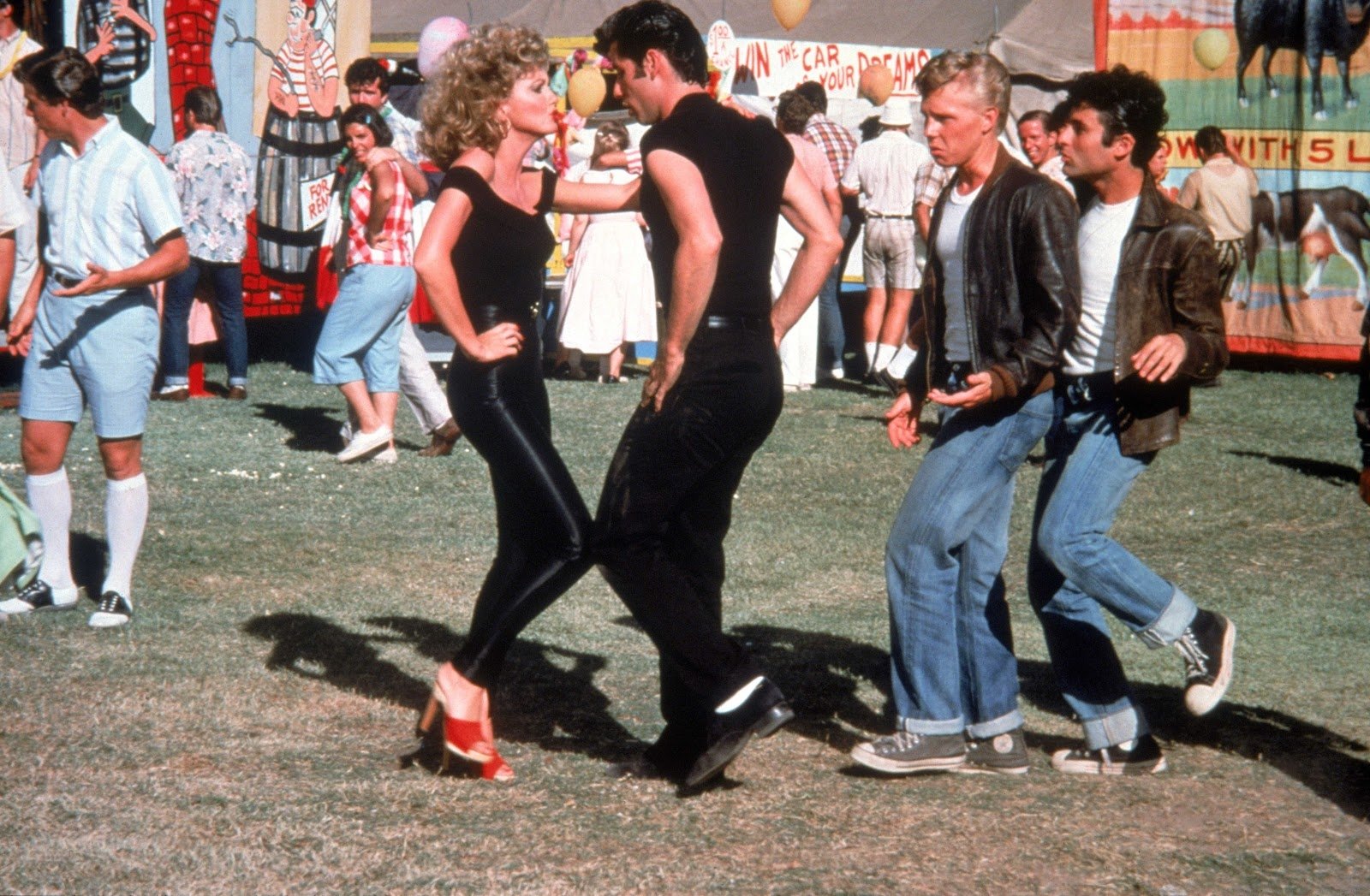 HD PC desktop wallpaper featuring a lively outdoor dance scene from the movie Grease, showcasing iconic characters in 1950s-style clothing.