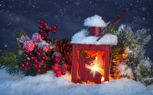 A festive HD Christmas wallpaper featuring a lit red lantern, snow-covered pine branches, and clusters of red currants, set against a dark, snowy background.