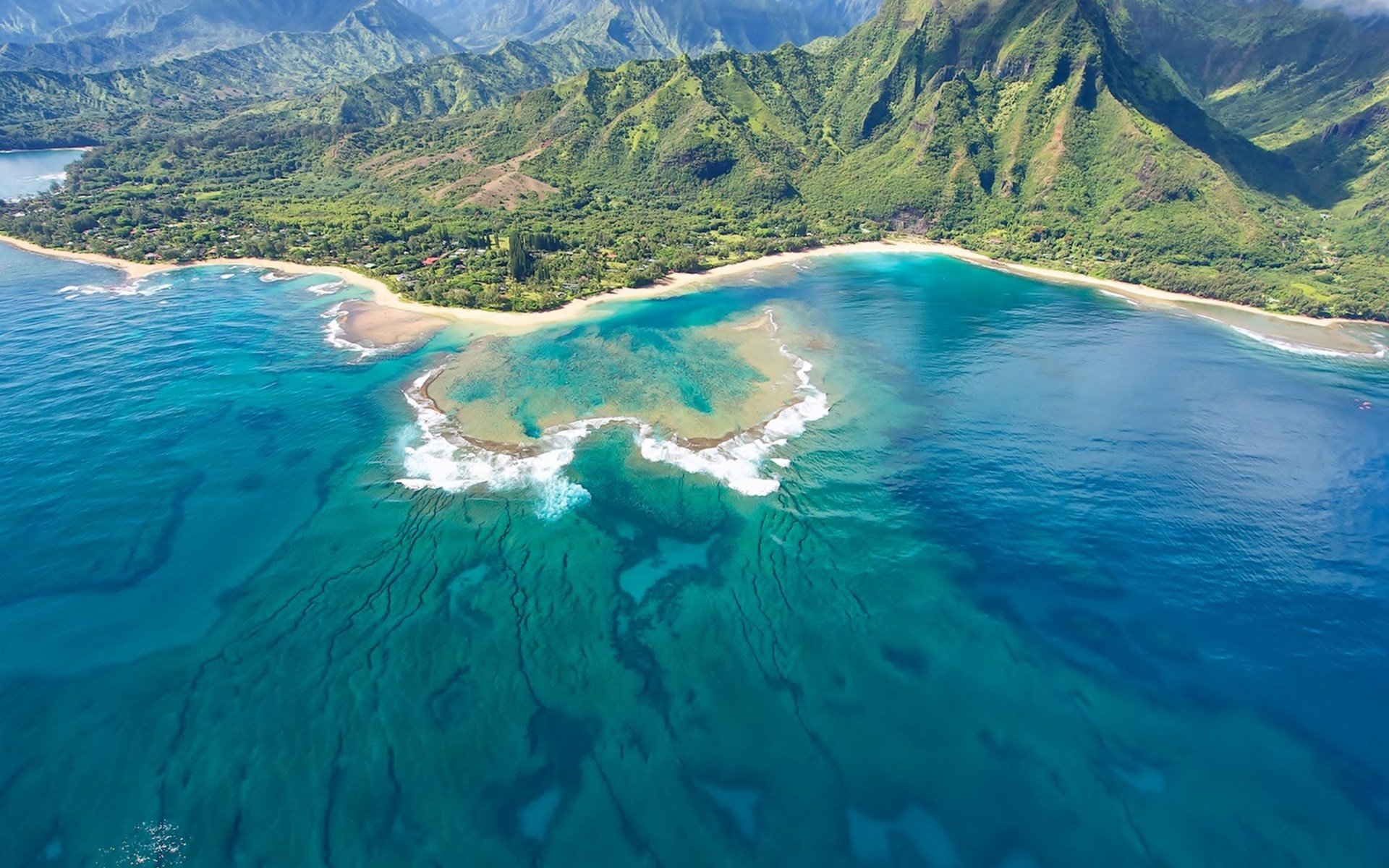 A vibrant HD PC desktop wallpaper showcasing a stunning seascape with clear turquoise waters, white sandy beaches, and lush green mountains under a bright sky.