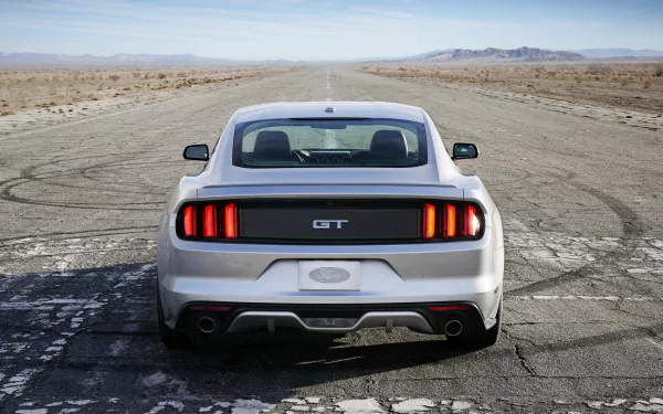 Rear view of a white 2015 Ford Mustang GT parked on a cracked desert road, captured in HD for a PC desktop wallpaper and background.