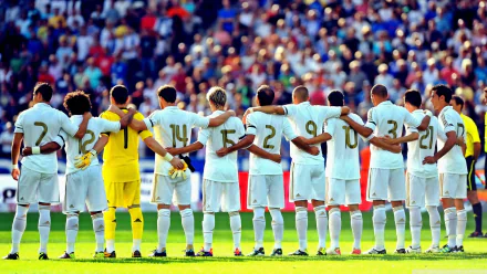 Real Madrid C.F. players stand united in a line on the field with their arms around each other. The image is a high-definition (HD) desktop wallpaper and background, highlighting sportsmanship.