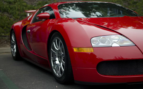 A striking red Bugatti Veyron parked, showcasing its sleek design and powerful stance, making it an impressive element for any HD desktop wallpaper.