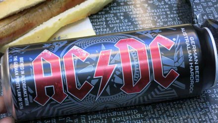 HD PC desktop wallpaper featuring a close-up of an AC/DC branded Australian Lager beer can alongside food, highlighting the band's logo and beer design.