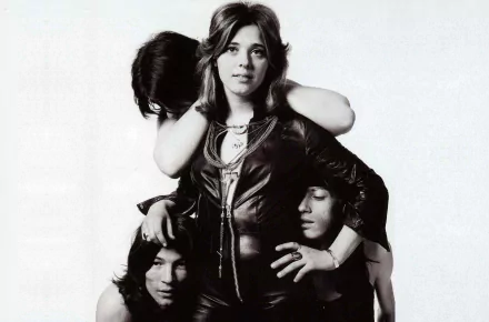 Black-and-white HD desktop wallpaper featuring Suzi Quatro posing confidently with band members, capturing a classic music moment.