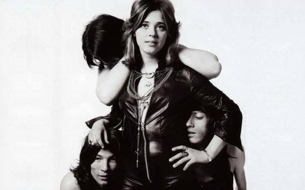 Black-and-white HD desktop wallpaper featuring Suzi Quatro posing confidently with band members, capturing a classic music moment.