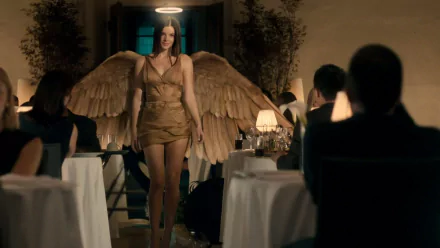 A woman in stunning angelic cosplay with large wings walks confidently through a restaurant, capturing attention amid diners. This HD wallpaper adds a unique touch to any background.