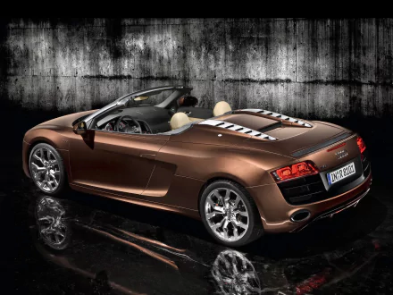 HD desktop wallpaper featuring a sleek brown Audi R8 V10 Spyder sports car against a textured dark background, showcasing the vehicle's luxury and design.