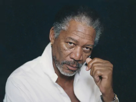 HD wallpaper of Morgan Freeman in a white shirt against a dark background, poised for a powerful desktop display.