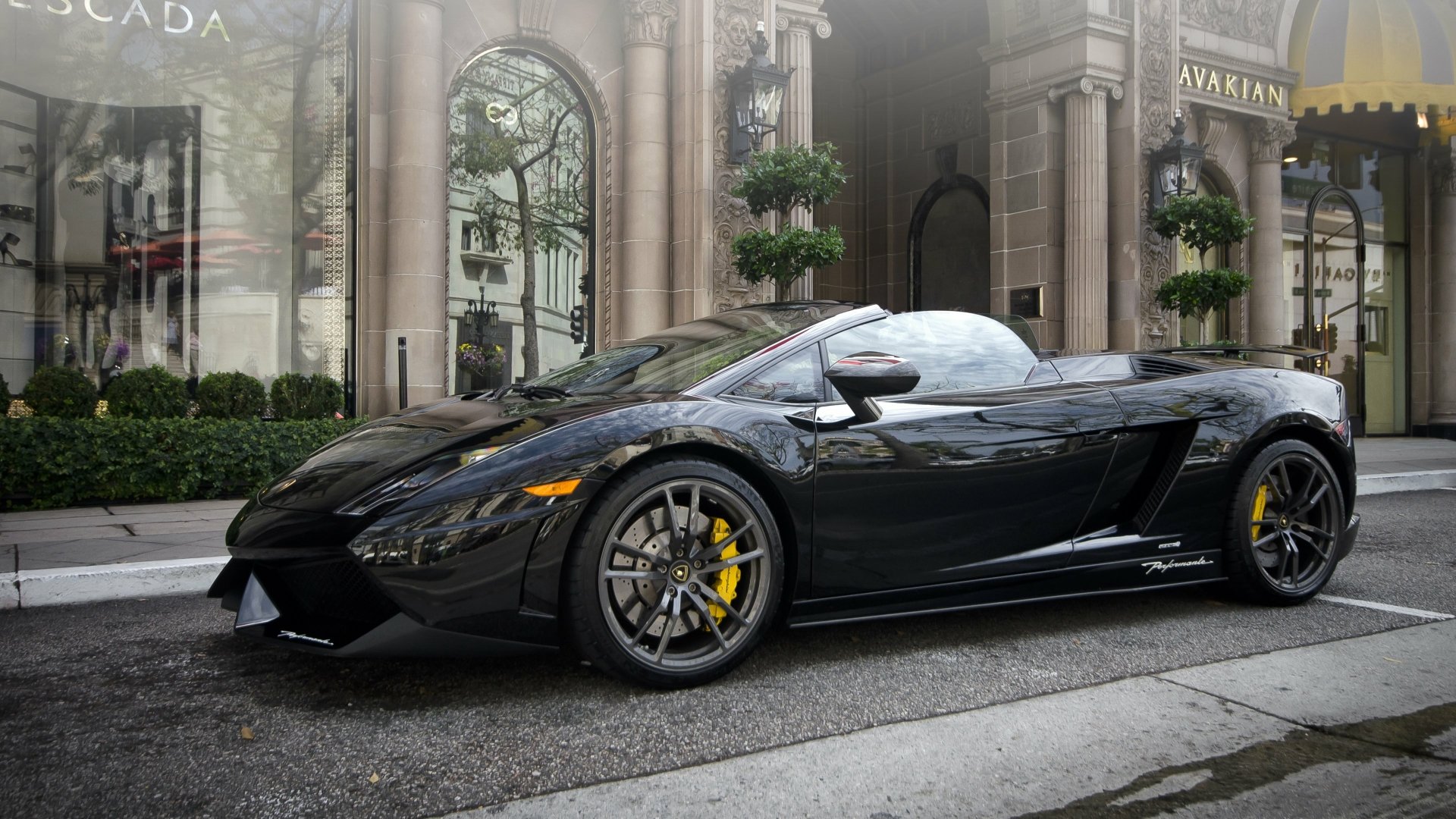 A sleek black Lamborghini Gallardo convertible parked on a city street, showcased in stunning 4K Ultra HD for PC desktop wallpaper and background.